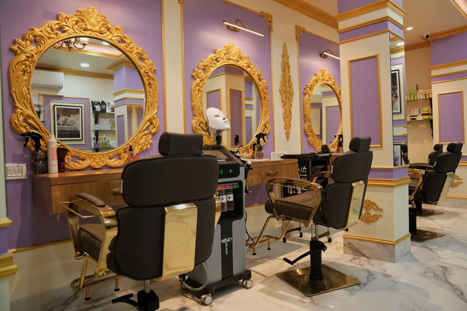The DIVINAA salon floor: lavender walls, gilded oval mirrors and styling chairs
